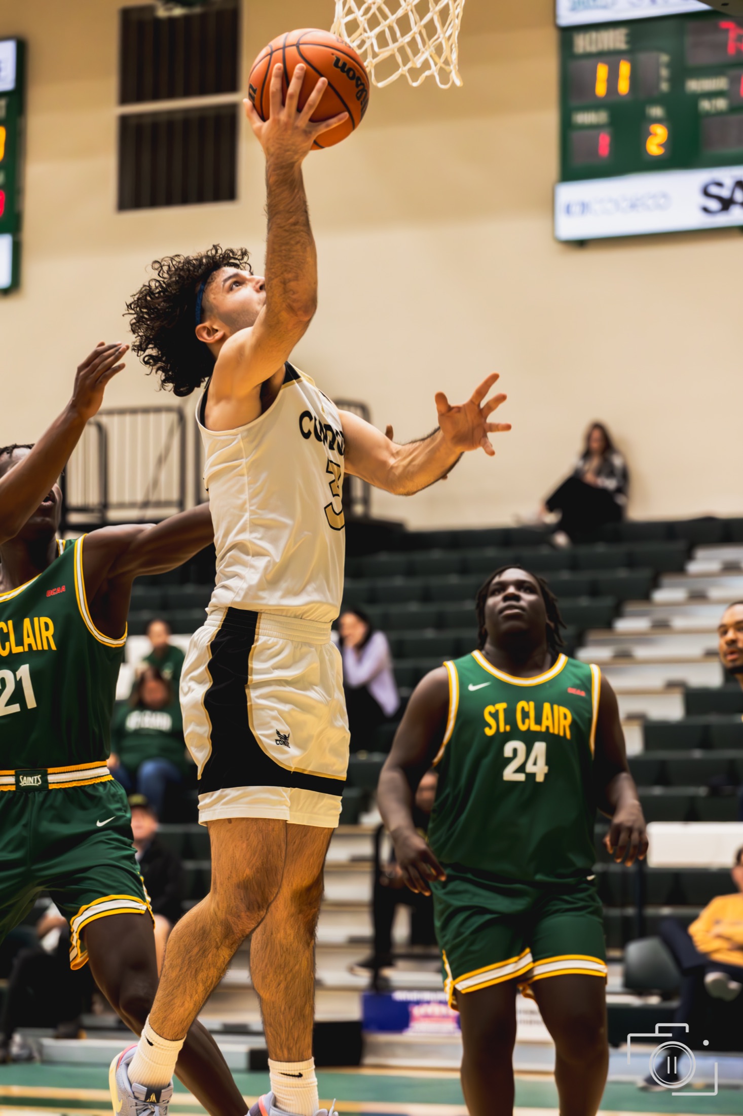 Basketball player going up for a layup in a college game — sports photography by Brian Mullin