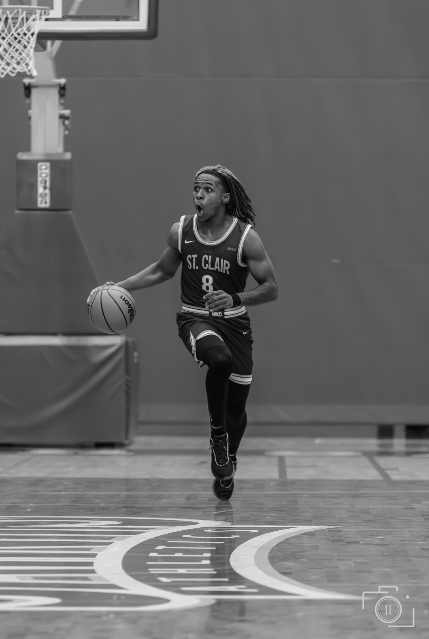 Basketball player dribbling at full speed during a college game, black and white — sports photography by Brian Mullin