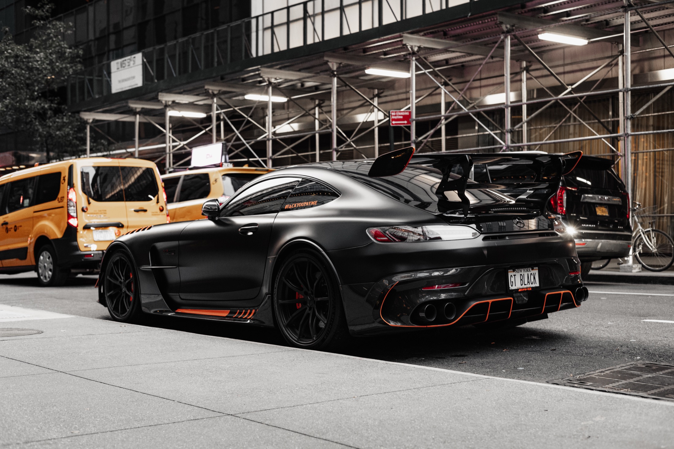 Mercedes-AMG GT Black Series on a New York City street at night, matte black with orange accents — brand photography by Brian Mullin