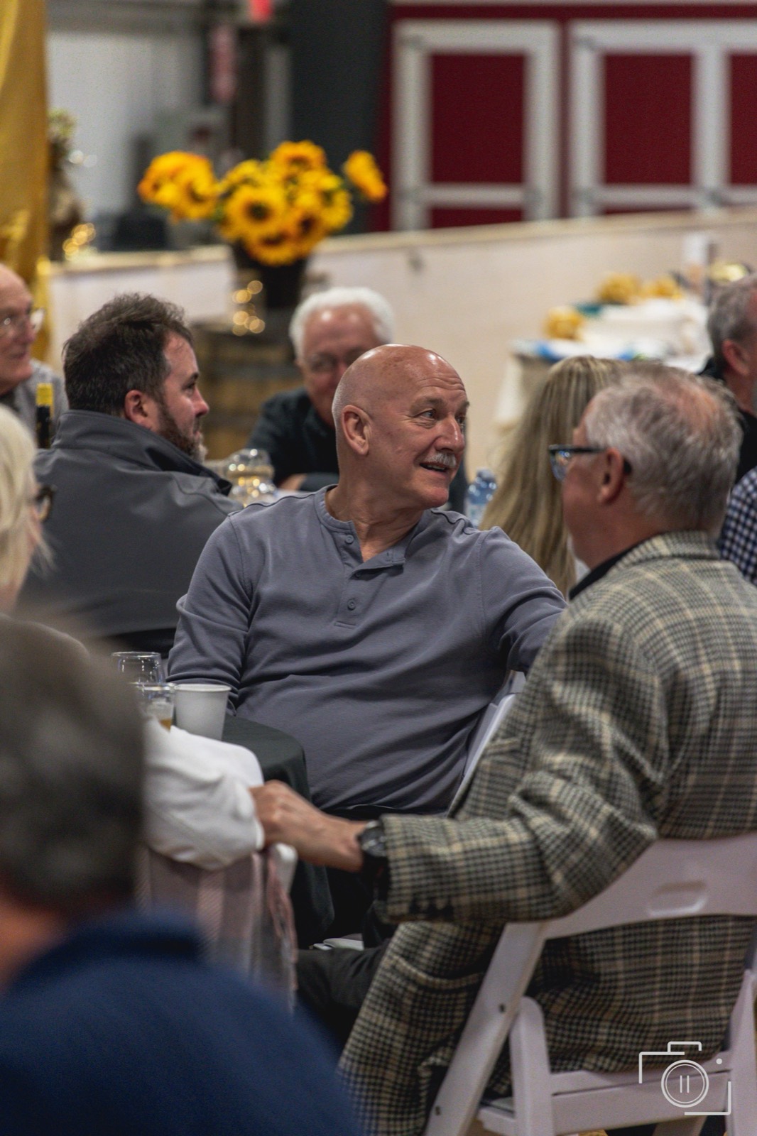 Candid table moment at a branded gala — the guest experience. Pause Studios.