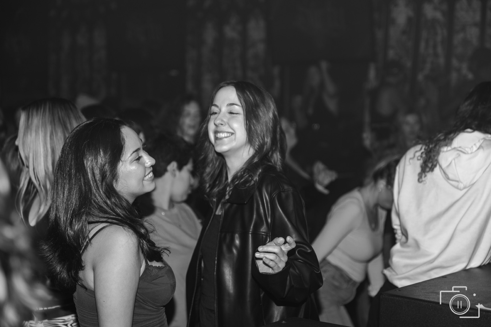 Two guests laughing together candidly at a branded event, black and white. Brand photography by Brian Mullin, Pause Studios.