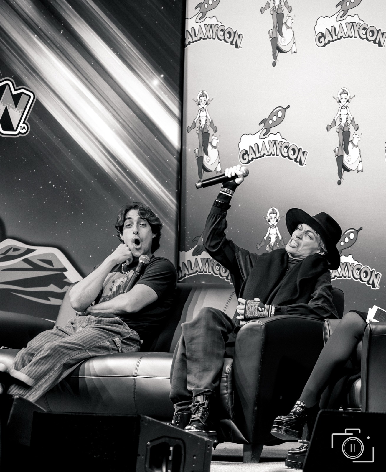 A loud, candid energy moment at a convention, in black and white. Pause Studios.