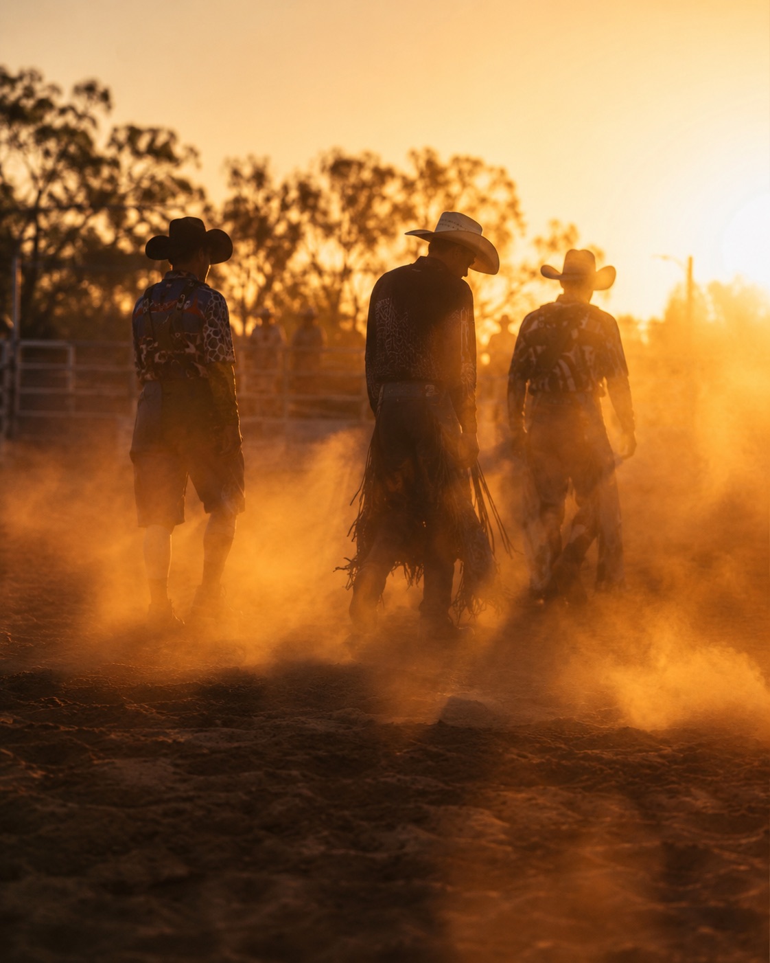 Cowboys silhouetted in golden arena dust at a rodeo — western event atmosphere by Brian Mullin, Pause Studios.