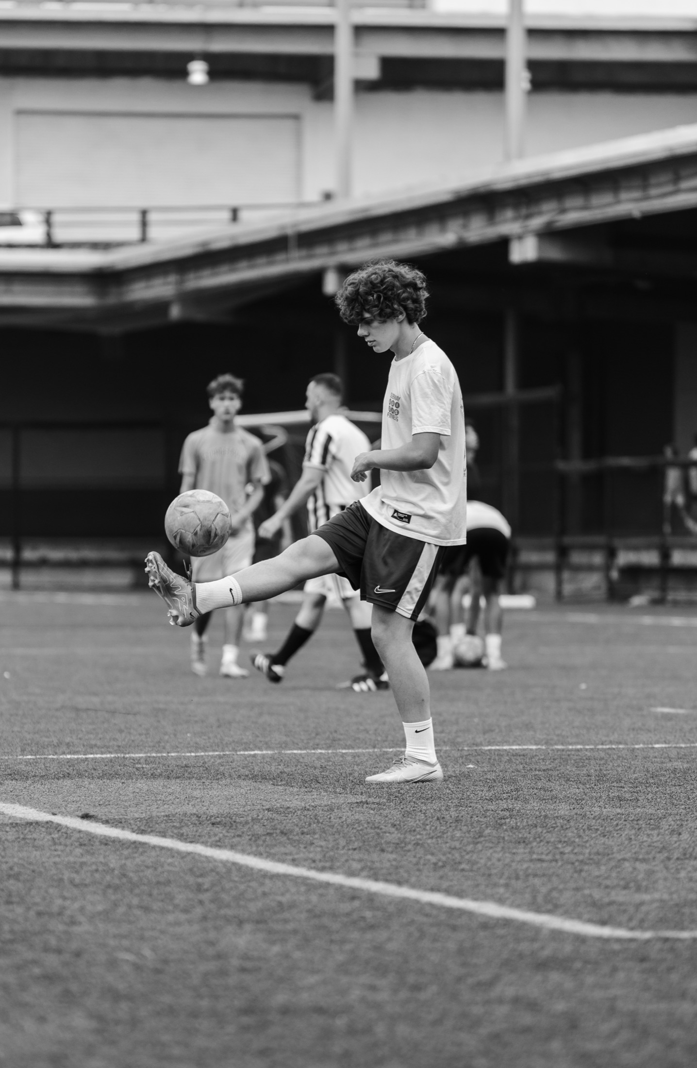Soccer player in mid-air challenge, black and white sports photography by Brian Mullin — Detroit area