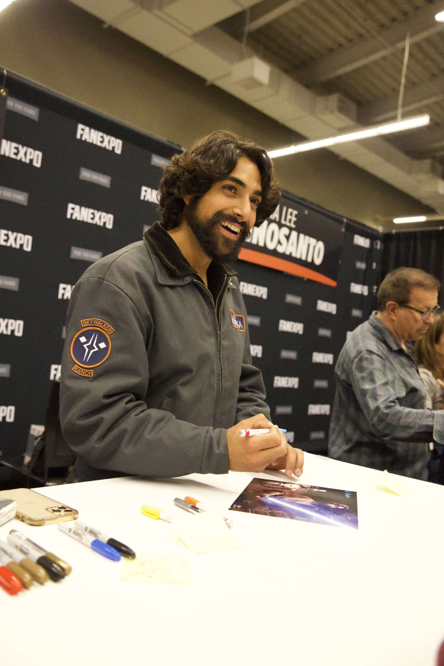 Eman Esfandi at the Fan Expo Cleveland signing table, laughing with fans in attendance