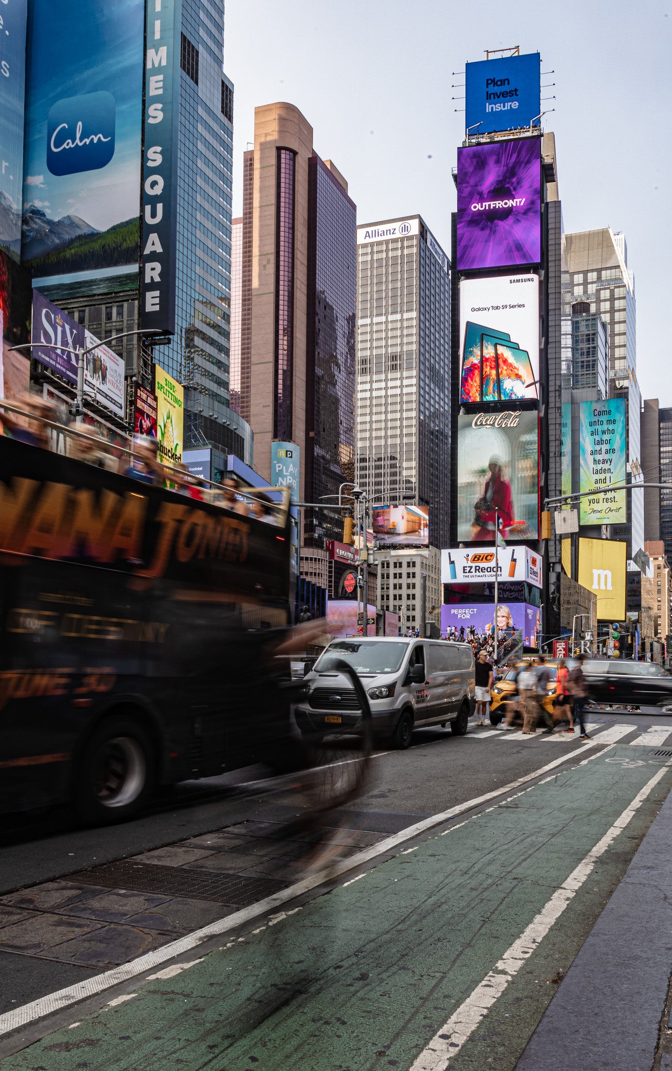 Times Square in motion — tour bus blur, taxis, and pedestrians beneath the billboards, New York. Editorial photography by Brian Mullin, Pause Studios.