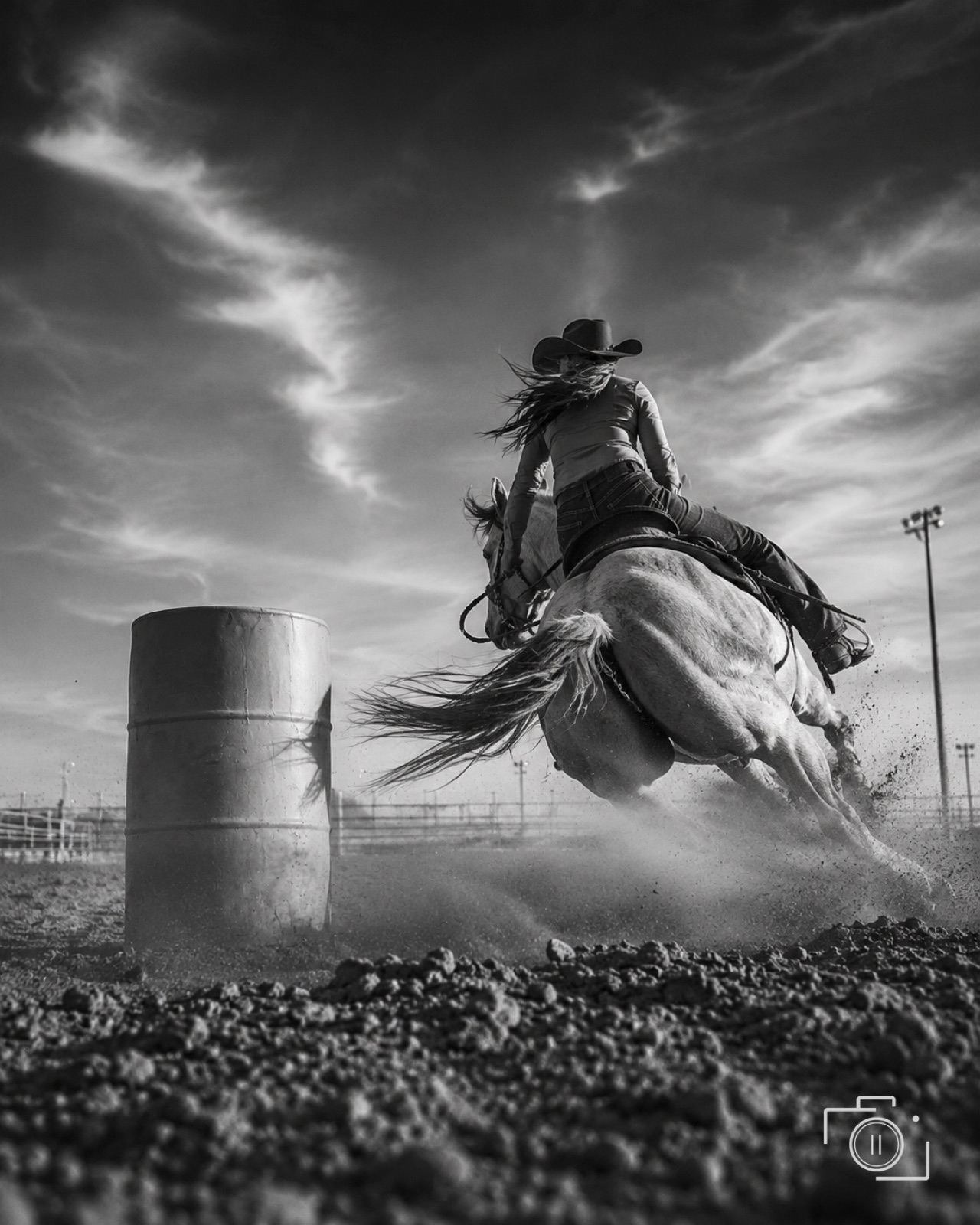 Barrel racer rounding the turn in a cloud of arena dust — western event coverage by Brian Mullin, Pause Studios.