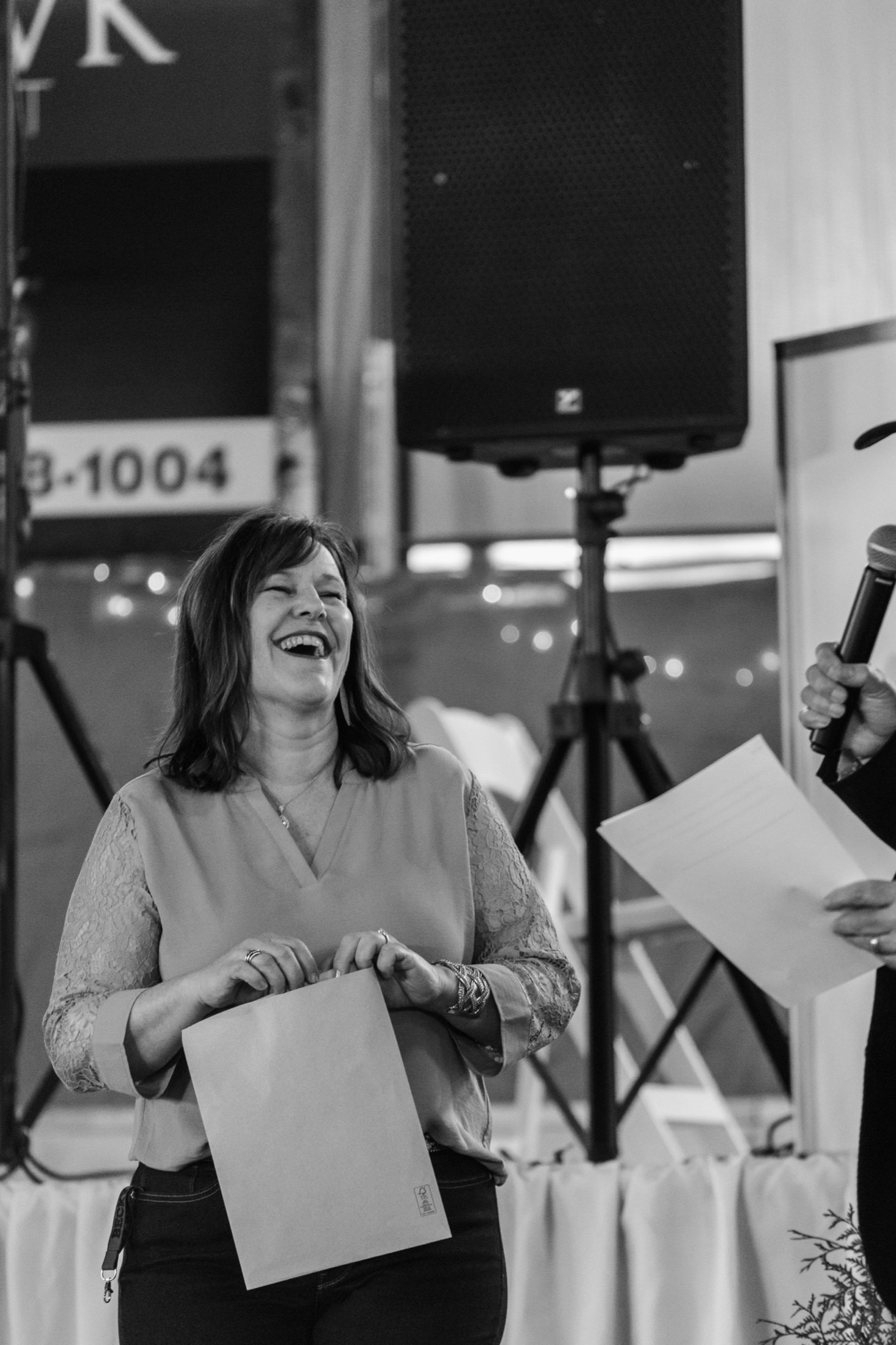 Guest laughing during an award presentation at the WETRA Blue Jean Bash fundraiser gala, Windsor Ontario 2023. Nonprofit event photography by Brian Mullin, Pause Studios.
