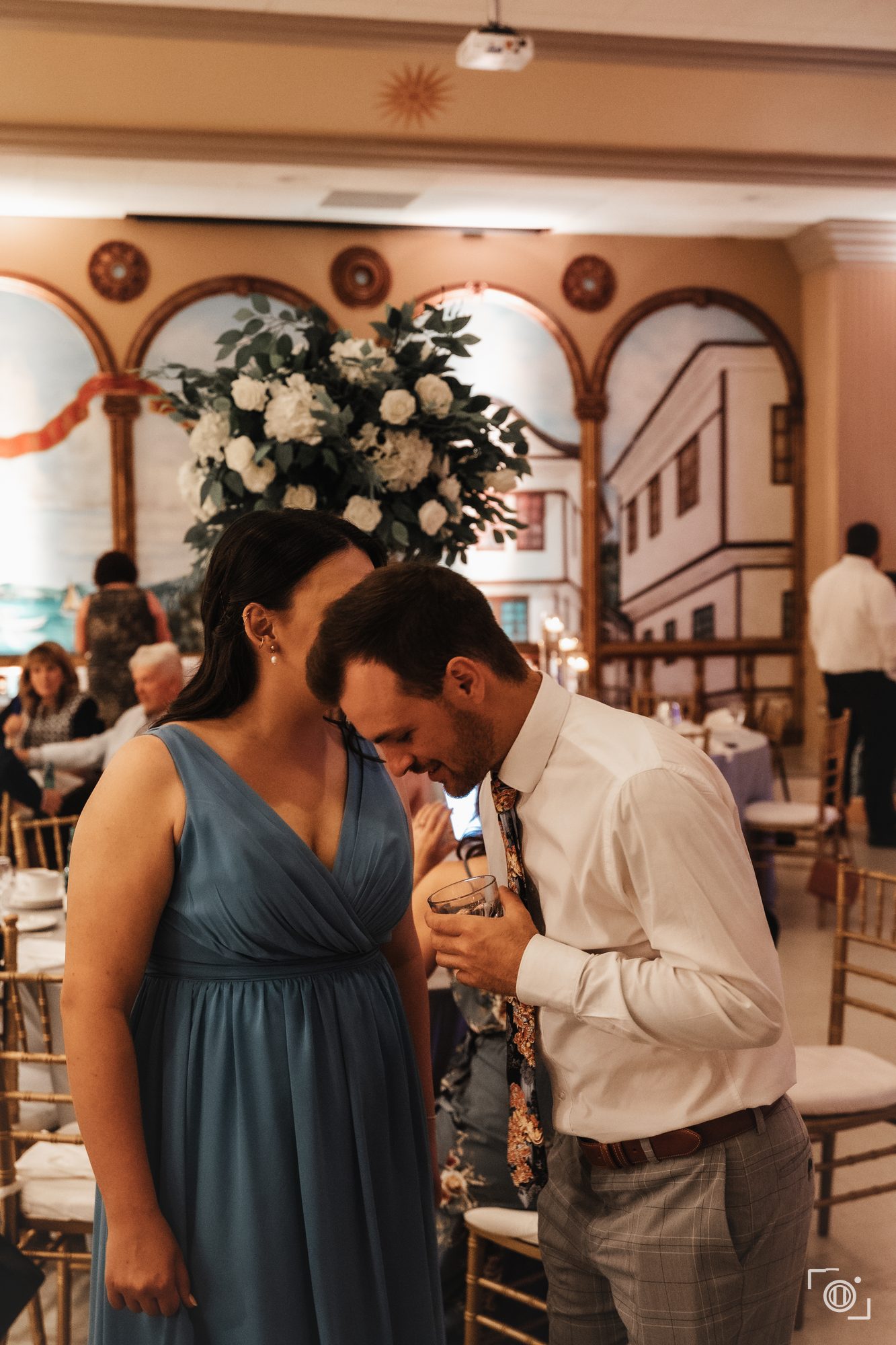 Bride and groom hold each other close at the reception under warm light. Documentary wedding coverage by Brian Mullin, Pause Studios.