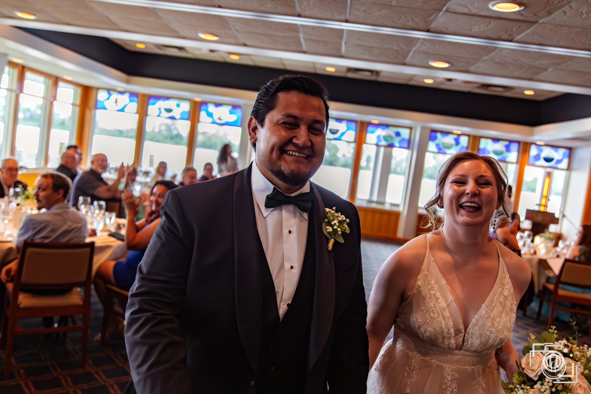 Bride and groom laughing together at the reception table. Documentary wedding coverage, Pause Studios.
