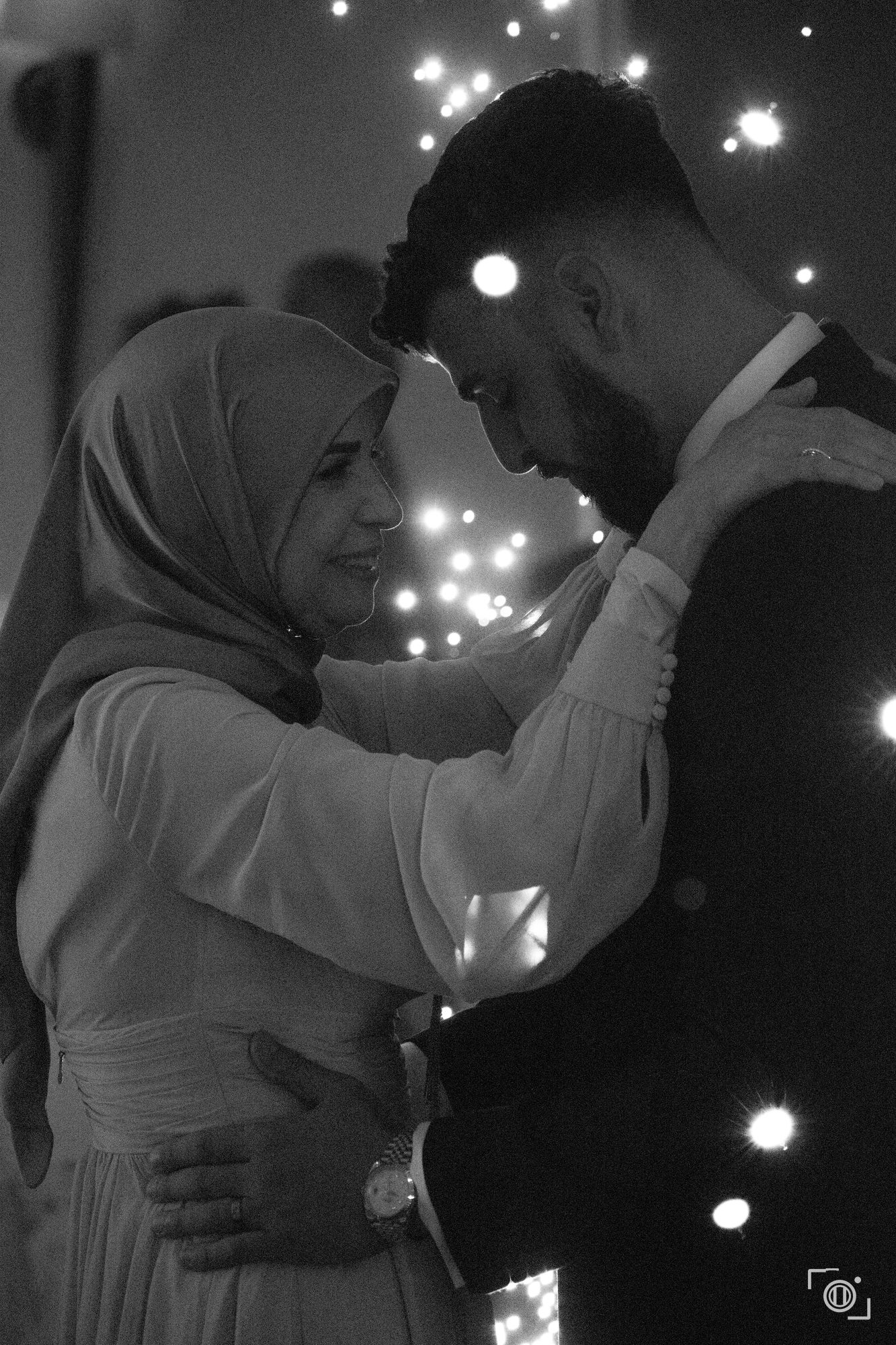 Couple hold each other close inside a ring of sparklers, black and white. Intimate wedding photography by Brian Mullin, Pause Studios.