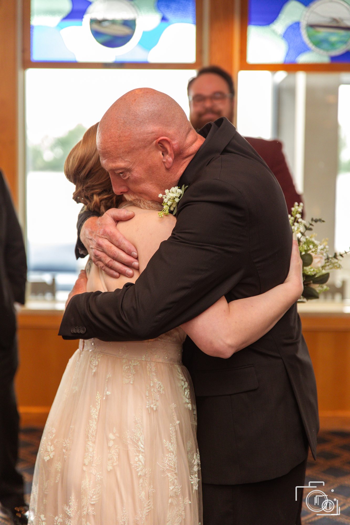 Emotional embrace at the ceremony as family hold each other. Wedding photography by Brian Mullin, Pause Studios.